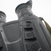 Close-up of a black binocular body with control buttons, showing the model marking 'HQ35L 0.5-22x60' and part of a tan strap against a white background.