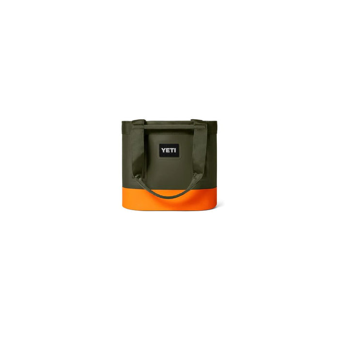 A YETI insulated tote bag in olive green with a bright orange bottom section and a black YETI logo patch on the front, set against a plain white background.
