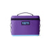 A purple YETI cooler bag with a black zipper, black handle, and a light blue bottom base, shown on a plain white background.