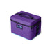 A purple YETI cooler bag with black handles and zipper pulls, featuring a black YETI logo patch on the front, set against a plain white background.