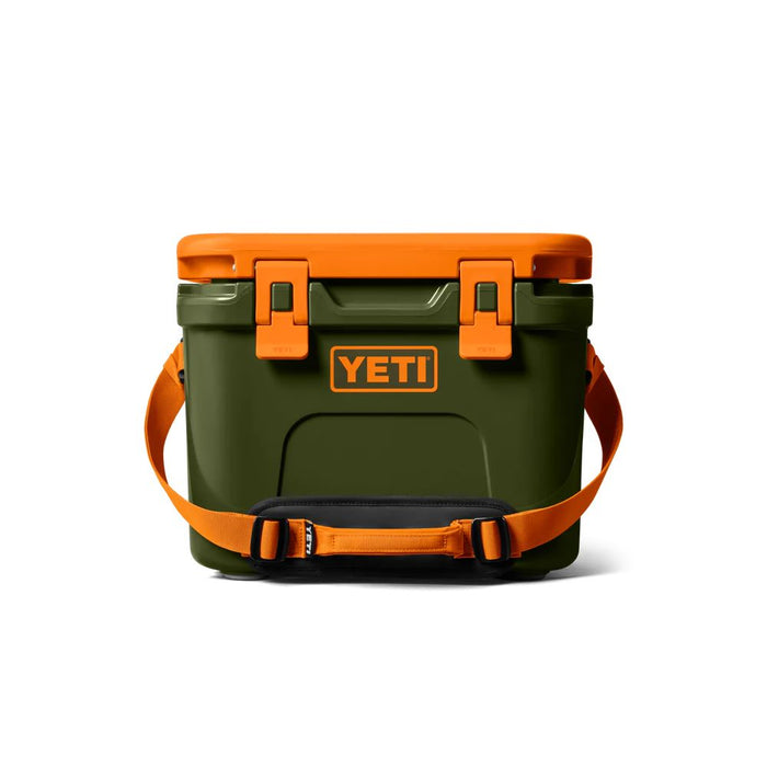 A YETI cooler in dark green with bright orange accents, including the lid, latches, handle, and logo border, shown on a clean white background.