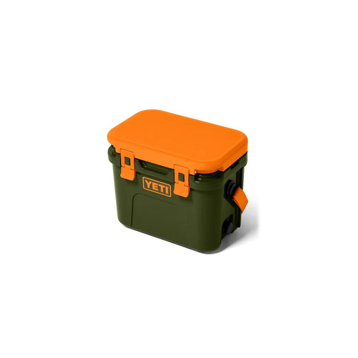 A YETI hard cooler in dark green with a bright orange lid and orange carrying handle, shown on a clean white background.