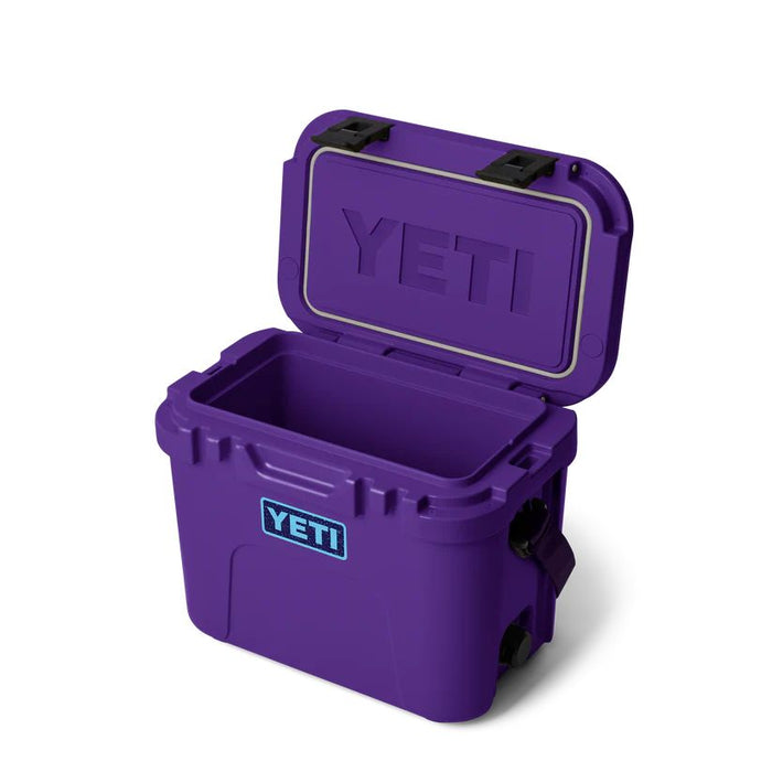 A purple YETI cooler with its lid open, showing the brand logo on the front and inside the lid, set against a plain white background.