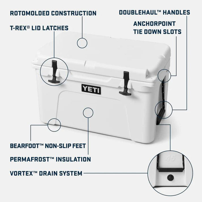 White YETI cooler with callout labels pointing to features such as rotomolded construction, T-REX lid latches, doublehaul handles, anchorpoint tie down slots, bearfoot non-slip feet, permafrost insulation, and vortex drain system.